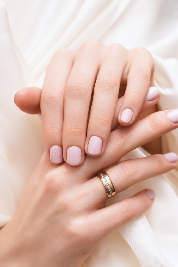 Pink nail design. Female hands with glitter manicure.